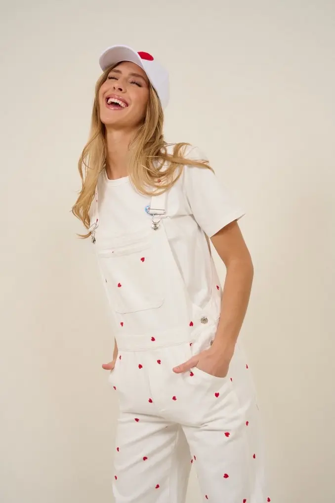 On propose une salopette pour femme en jean blanc et des broderies pour un effet estival.